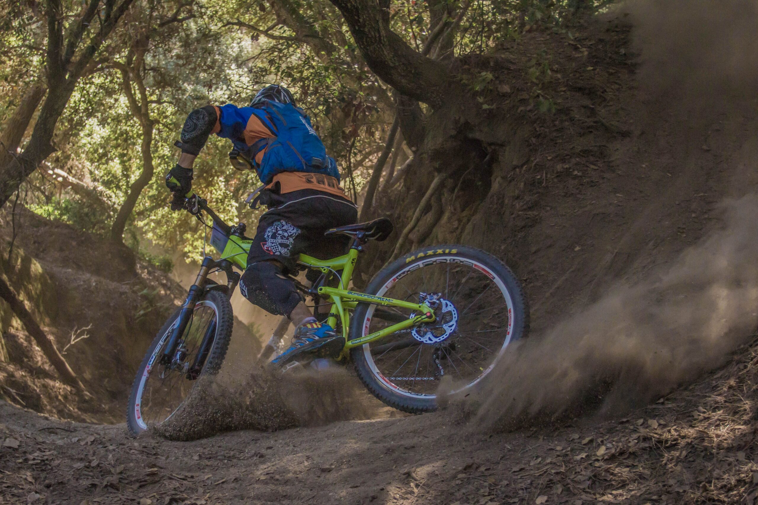 Mountainbiker zieht eine Staubwolke auf einem Downhill-Trail